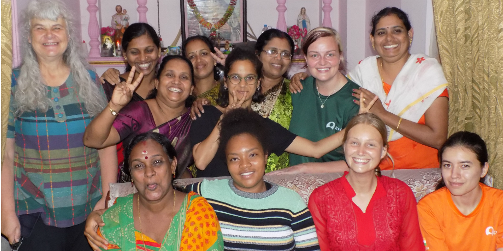 Voluntarios y mujeres de Kerala de pie frente a un santuario tradicional.