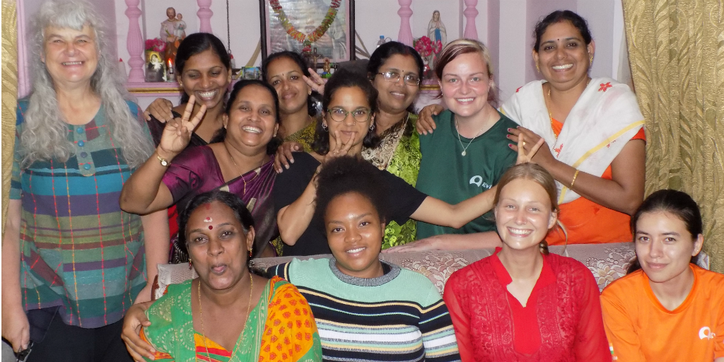 vrijwilligers en vrouwen uit Kerala die voor een traditioneel heiligdom staan.