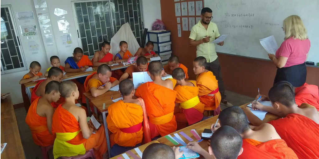 dobrovolníci vyučují angličtinu začínajícím mnichům v Laosu.