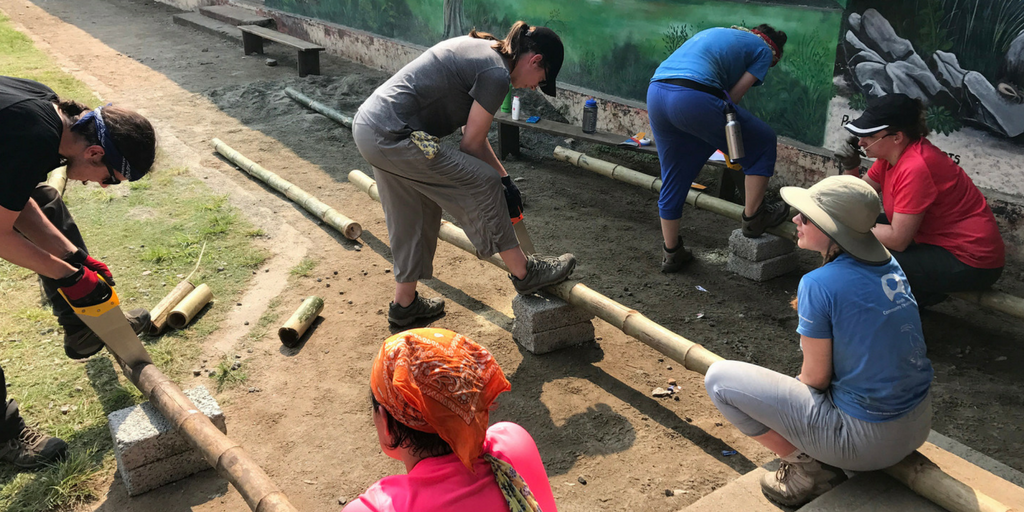 GVI volunteers in Kerala work at putting up a new playground at the local school.